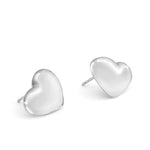 Echtzeit Ohrstecker - Puffy Heart: Silberne, herzförmige Ohrstecker mit glatter, glänzender Oberfläche von Echtzeit - ideal als romantisches Accessoire für jeden Anlass. Auf einfarbig weißem Hintergrund dargestellt.