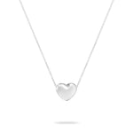 Die Echtzeit Halskette - Puffy Heart von Echtzeit zeigt einen polierten Herzanhänger an einer schlichten Silberkette, die jedem Look zeitlose Eleganz verleiht. Präsentiert vor einem weißen Hintergrund.