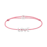 Das Echtzeit Armband - Love Letters von Echtzeit besteht aus einem rosafarbenen Stoffband, einem silbernen LOVE Buchstabenanhänger und einem verstellbaren Verschluss.