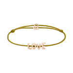 Das Echtzeit Armband - Love Letters von Echtzeit besteht aus einem olivgrünen Band mit goldenen LOVE-Buchstaben-Anhängern und einem kleinen goldenen Verschluss - ein ideales, sinnvolles Geschenk.