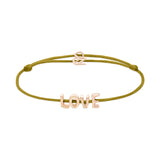 Das Echtzeit Armband - Love Letters von Echtzeit besteht aus einem olivgrünen Band mit goldenen LOVE-Buchstaben-Anhängern und einem kleinen goldenen Verschluss - ein ideales, sinnvolles Geschenk.