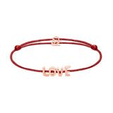 Das Echtzeit Armband - Love Letters von Echtzeit hat eine rote Kordel mit goldenen LOVE-Buchstaben und einem "oz"-Anhänger - perfekt als Geschenk für einen besonderen Menschen.