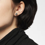 Nahaufnahme einer Person mit kurzen dunklen Haaren und einem schwarzen Oberteil, die LIEBESKIND BERLIN Ohrstecker - The Iconic Geometric von Liebeskind Berlin trägt.