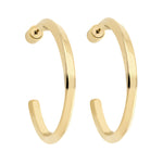 Die LIEBESKIND BERLIN Creole - Twisted Ohrringe von Liebeskind Berlin zeichnen sich durch ein glänzendes, goldfarbenes, gedrehtes Design und offene Enden aus Edelstahl aus, die vor einem weißen Hintergrund präsentiert werden.