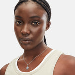 Liebeskind Berlin Halskette bestehend aus einer silbernen Ankerkette und einem drehbaren Anhänger mit graviertem Logo auf der einen und graviertem Logoschriftzug auf der anderen Seite; Tragebild