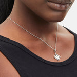 Liebeskind Berlin Halskette bestehend aus einer silbernen Ankerkette und einem drehbaren Anhänger mit graviertem Logo auf der einen und graviertem Logoschriftzug auf der anderen Seite; Tragebild