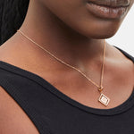 Liebeskind Berlin Halskette bestehend aus einer roségoldenen Ankerkette und einem drehbaren Anhänger mit graviertem Logo auf der einen und graviertem Logoschriftzug auf der anderen Seite; Tragebild