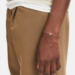 Liebeskind Berlin Armband bestehend aus einer doppelten, roségoldenen Ankerkette und einem drehbaren Anhänger mit graviertem Logo auf der einen und graviertem Logoschriftzug auf der anderen Seite; Tragebild