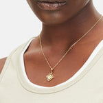Goldener Liebeskind Berlin Charm mit drehbarem Plättchen, graviertem Fische-Zodiac-Symbol auf der einen und Logoschriftzug auf der anderen Seite; Tragebild