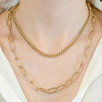 Das LIEBESKIND BERLIN Halsketten-Set - The Layering von Liebeskind Berlin, bestehend aus goldenen Ketten mit kleinen und großen Gliedern, wird elegant über ein weißes Hemd gestylt.