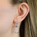 Nahaufnahme eines Frauenohrs mit LIEBESKIND BERLIN Ohrhänger - The Must-Have by Liebeskind Berlin, das die eleganten Edelstahlohrringe als zeitloses Accessoire präsentiert.