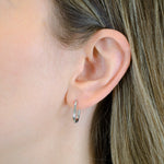 Nahaufnahme des Ohrs einer Person mit glattem hellbraunem Haar, die LIEBESKIND BERLIN Ohrhänger - The Must-Have by Liebeskind Berlin trägt.