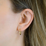 Nahaufnahme eines Frauenohrs mit heller Haut und hellbraunem Haar. Sie trägt LIEBESKIND BERLIN Ohrhänger - The Must-Have by Liebeskind Berlin, einen eleganten, zeitlosen goldenen Creolenring.