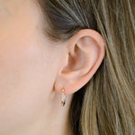 Nahaufnahme einer Frau mit glattem hellbraunem Haar, die den LIEBESKIND BERLIN Ohrhänger - The Must-Have von Liebeskind Berlin trägt und damit echten Berliner Stil demonstriert.