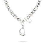 Die LIEBESKIND BERLIN Halskette - The Organic von Liebeskind Berlin besticht durch eine Panzerkette aus Edelstahl mit abstraktem, ovalem Anhänger und rundem Tag, präsentiert auf weißem Hintergrund.