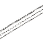 Drei silberne Ketten mit einzigartigen Gliedern, darunter die LIEBESKIND BERLIN Fußkette - Sparkling With Layers, sind diagonal auf weißem Grund angeordnet - ein stilvolles Accessoire von Liebeskind Berlin.