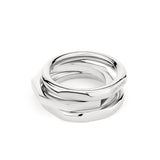 Der LIEBESKIND BERLIN Ring - Urban Chic in Größe 56 besteht aus drei ineinander verschlungenen Silberringen, von denen einer mit Liebeskind Berlin graviert ist. Sie bilden ein auffälliges Ensemble auf weißem Hintergrund.