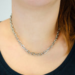 Eine Person trägt die LIEBESKIND BERLIN Halskette - The Double Tag von Liebeskind Berlin mit einem dunklen Oberteil und teilweise sichtbaren Haaren - ein schicker Style für Damen Schmuck Fans.