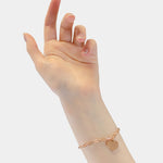 Eine Hand trägt das LIEBESKIND BERLIN Armband - My Heart von Liebeskind Berlin, dessen goldene Kette und Herzanhänger sanft das Licht einfangen - ein Stück, das moderne Eleganz verkörpert.