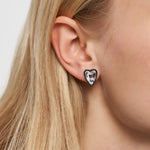 Nahaufnahme eines Ohrs mit einem LIEBESKIND BERLIN Ohrstecker - Glasherz von Liebeskind Berlin und glattem blondem Haar.