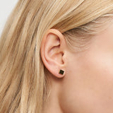 Nahaufnahme eines Frauenohrs mit glattem blondem Haar, das einen kleinen quadratischen Liebeskind Berlin Ohrring - Plates trägt - ideal für Fans von minimalistischem Schmuck.