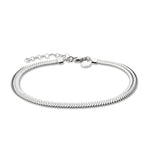 Die Liebeskind Berlin Fußkette - The Sleek ist eine silberne Fischgrätenkette mit verstellbarem Verschluss und einem kleinen runden Anhänger, der den charakteristischen Stil der Marke widerspiegelt. Abgebildet auf einem weißen Hintergrund.