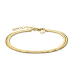 Die Liebeskind Berlin Fußkette - The Sleek von Liebeskind Berlin ist eine goldene Fischgrätenkette mit einem verstellbaren Verschluss und einem kleinen runden Anhänger aus Edelstahl auf weißem Grund.