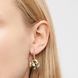 Nahaufnahme eines Frauenohrs mit Liebeskind Berlin Ohrring - Organic Shapes und zwei kleinen, organisch geformten Ohrsteckern im oberen Knorpel - ein modernes Accessoire von Liebeskind Berlin für jeden Look.