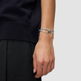 Das LIEBESKIND BERLIN Armband - Lora, ein blaues Stoffarmband mit silbernem Knotenanhänger, von Liebeskind Berlin ist ein schickes Damen-Accessoire für dunkle Kleidung.