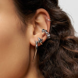 Nahaufnahme eines Ohrs, das mit silbernen Ohrringen geschmückt ist - einem großen Spike, kleinen Creolen, Ohrsteckern und dem LIEBESKIND BERLIN Earcuff - Spikes von Liebeskind Berlin, einem stilvollen Accessoire, das urbanes Design zeigt.