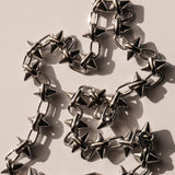 Die LIEBESKIND BERLIN Halskette - Spikes von Liebeskind Berlin ist mit ihrem glänzenden Metall und den spitzen Stacheln, die kühne Schatten werfen, ein auffälliges Statement-Stück.