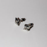 Ein Paar LIEBESKIND BERLIN Ohrstecker - Spikes von Liebeskind Berlin mit glänzendem, geometrischem Design, Silikonverschluss und dezentem Spikes-Muster wird auf einem schlichten weißen Hintergrund präsentiert.