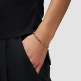 Eine Person mit der Hand in der Tasche einer schwarzen Hose trägt das Liebeskind Berlin Armband - Urban Chic und unterstreicht damit seinen anpassbaren Stil und sein urbanes Design.