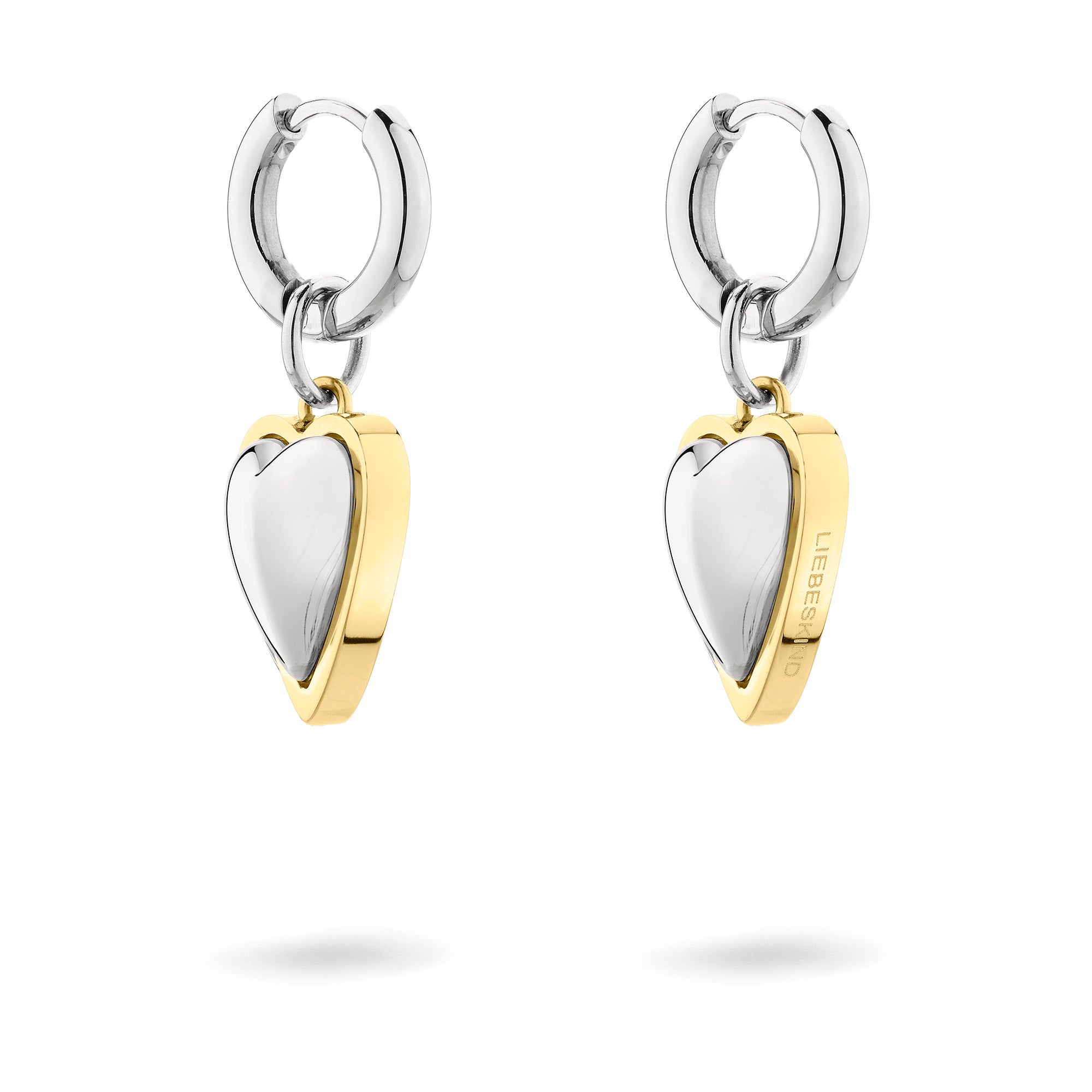 LIEBESKIND BERLIN Creole - Metall-Ohrringe von Liebeskind Berlin: Gold- und silberfarbene, herzförmige Creolen mit eingravierten Seitendetails auf weißem Grund.