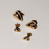 Vier goldene Ohrstecker in Herzform aus der Kollektion "Metal Heart" von Liebeskind Berlin sind auf einem schlichten weißen Hintergrund angeordnet - ein stilvolles Schmuckstück von Liebeskind Berlin Ohrstecker.