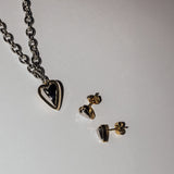 Ein LIEBESKIND BERLIN Ohrstecker - Metal Heart von Liebeskind Berlin und eine schwarze Halskette mit Anhänger, die auf weißem Untergrund präsentiert wird, sind perfekt, um jeden Look mit stilvollem Schmuck zu ergänzen.