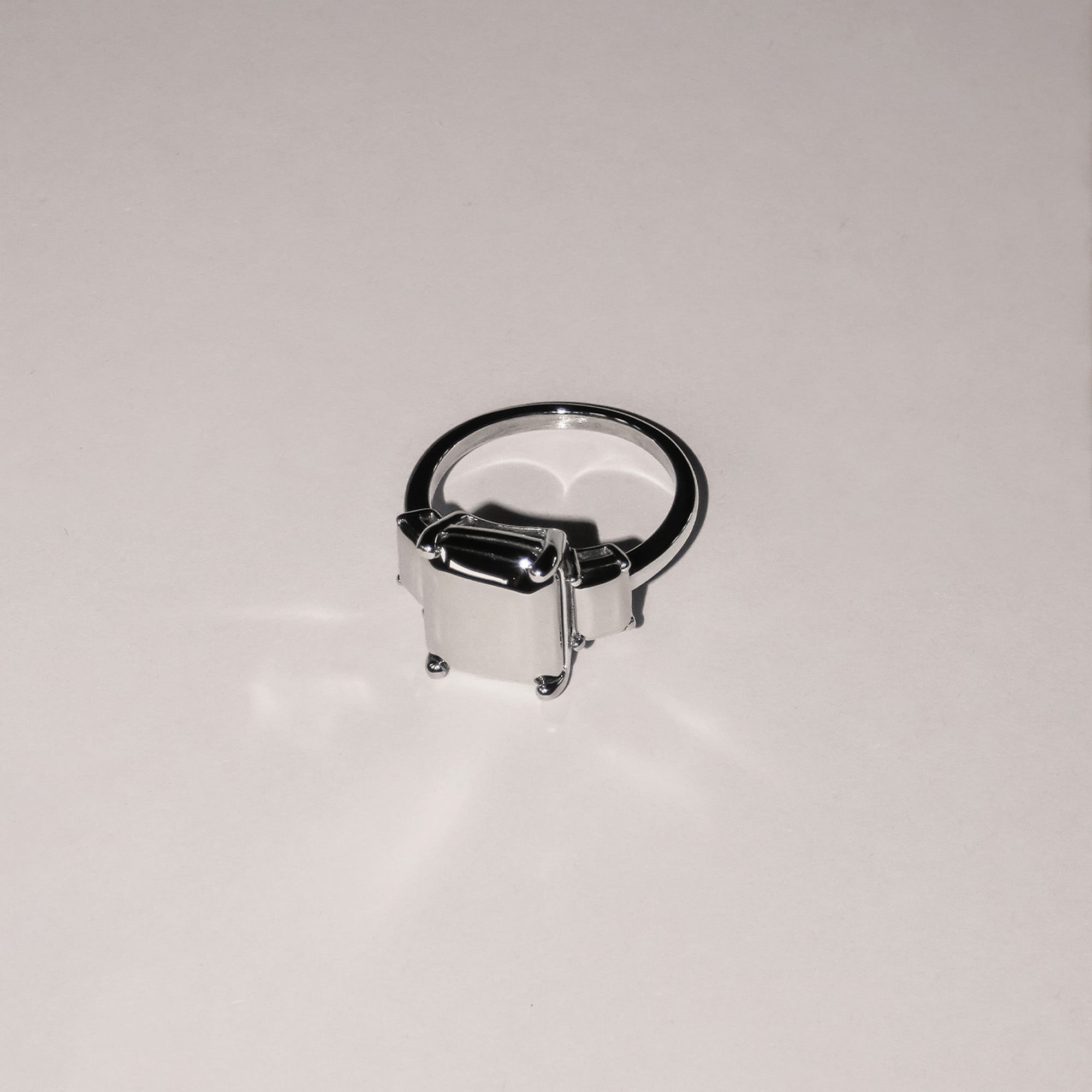 Der LIEBESKIND BERLIN Ring - Steel Diamond in Größe 54 von Liebeskind Berlin zeichnet sich durch eine kastenförmige, rechteckige Fassung in Diamantoptik aus, die auf einem schlichten weißen Hintergrund abgebildet ist.