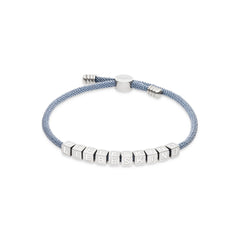 Das LIEBESKIND BERLIN Armband - Brick von Liebeskind Berlin besteht aus einem hellblauen Textilband mit silbernen Würfelperlen, die den Schriftzug LIEBESKIND tragen - ein auffälliges Stück aus der Armband-Kollektion, das auf weißem Hintergrund gezeigt wird.