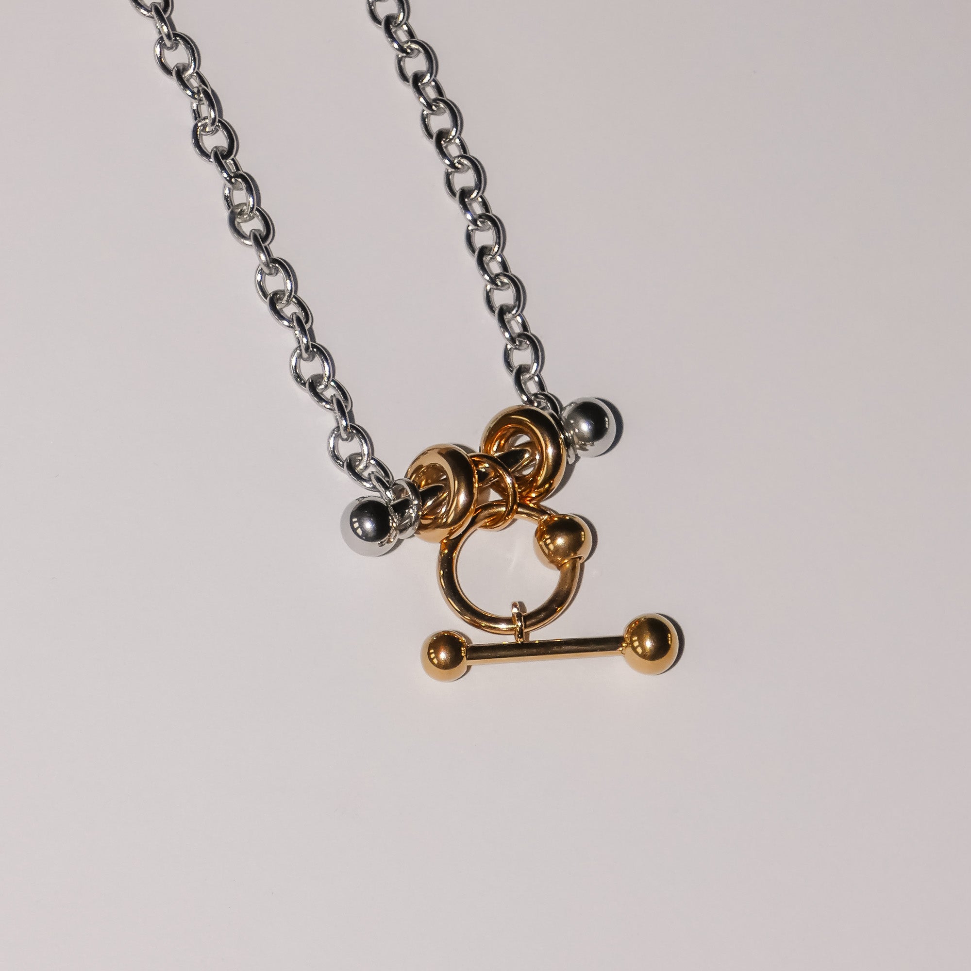 Die LIEBESKIND BERLIN Halskette - Urban Chic von Liebeskind Berlin besteht aus einer silbernen Kette mit goldenen und silbernen runden und stabförmigen Anhängern im modernen Bicolor-Stil - ein zeitloses Design, das perfekt für vielseitige Looks ist.