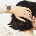 Liebeskind Berlin Armbanduhr mit schwarzem Zifferblatt, goldenen Indizes, goldenem Gehäuse und goldenem Meshband; Tragebild