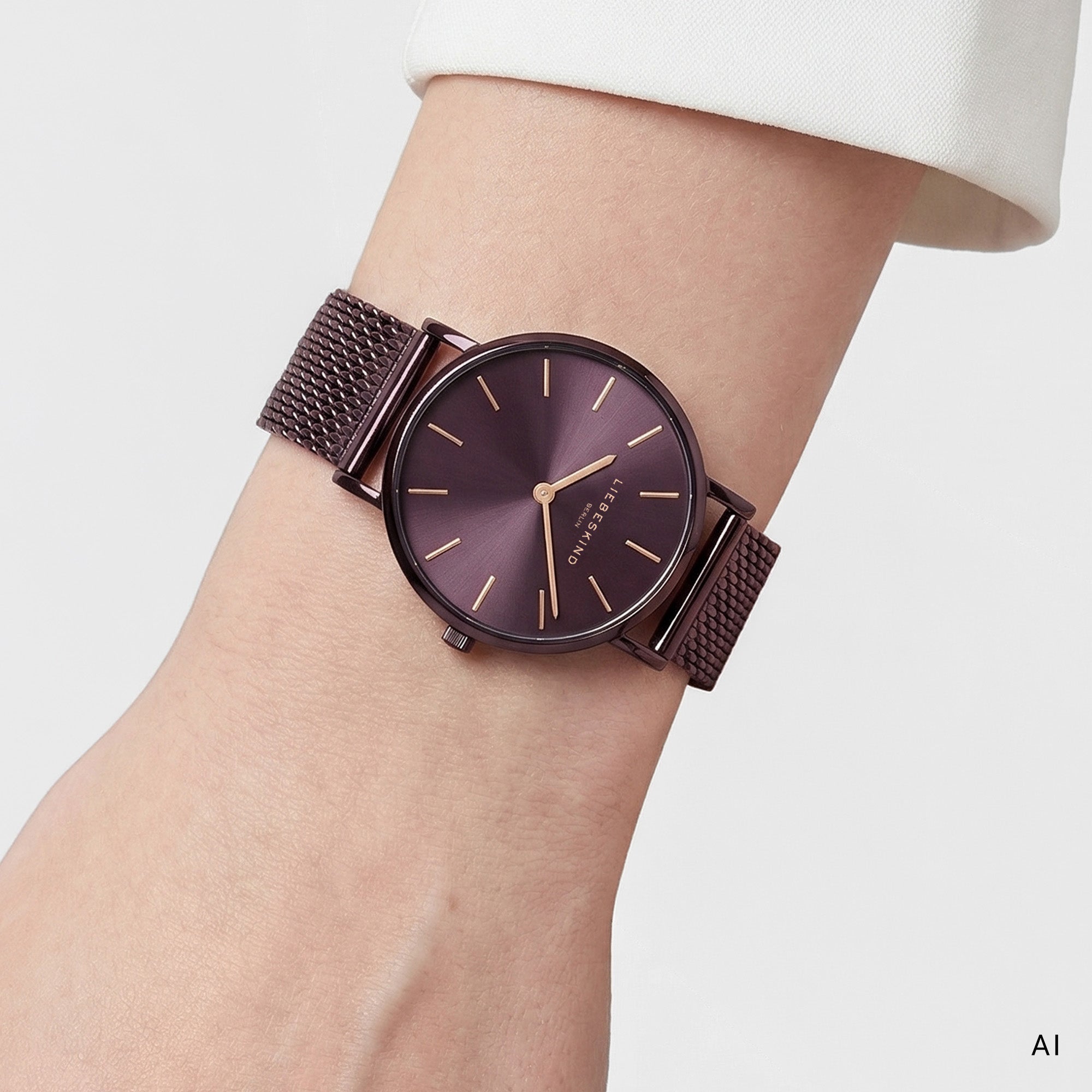 Ki generiertes Bild einer LIEBESKIND BERLIN Damenuhr mit violettem Edelstahl-Mesharmband, violettem Gehäuse und violettem Sunray-Zifferblatt mit goldfarbenen Zeigern und Indizes, getragen am Handgelenk.