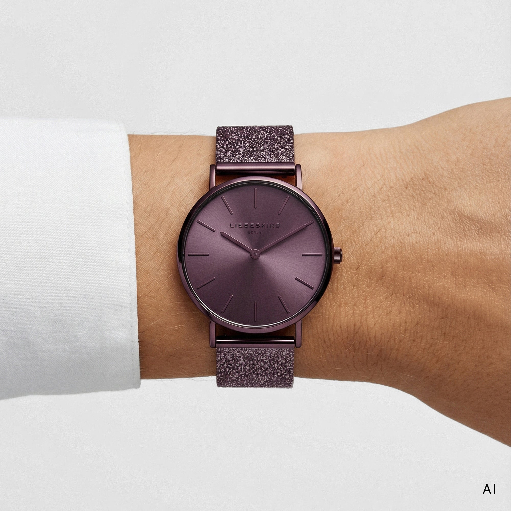 Ki generiertes Bild einer LIEBESKIND BERLIN Damenuhr mit violettem Gehäuse, violettem Sunray-Zifferblatt und glitzerndem violettem Lederarmband, getragen am Handgelenk.
