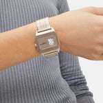 Eine Person in einem blauen gerippten Langarmhemd ergänzt ihren Stil mit der Liebeskind Berlin Armbanduhr - Vinyl Vision, die ein elegantes silbernes Design aufweist.