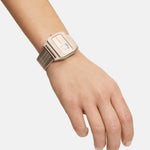 Eine Hand trägt die LIEBESKIND BERLIN Armbanduhr - Vinyl Vision, eine silberne Digitaluhr mit Metallnetzband von Liebeskind Berlin, vor einem schlichten Hintergrund.