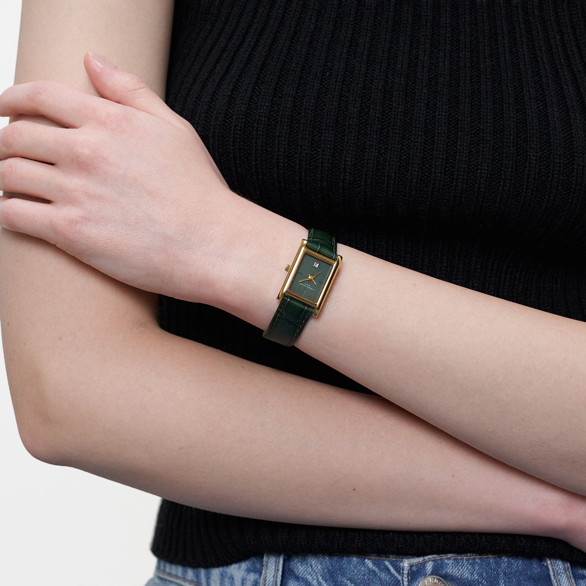 Nahaufnahme der getragenen LIEBESKIND BERLIN Damenarmbanduhr mit grünem Zifferblatt, goldfarbenem Gehäuse und dunkelgrünem Lederarmband.