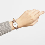 Eine Hand trägt die LIEBESKIND BERLIN Armbanduhr - The Vintage Must-Have von Liebeskind Berlin mit Lederarmband im Vintage-Look, Katzenohren auf dem Zifferblatt und minimalistischem skandinavischem Design.