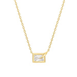Die ANIA HAIE Halskette - Sparkling Bezel von Ania Haie ist eine Goldkette mit einem rechteckigen Anhänger, der einen klaren Edelstein und einen markanten Goldakzent in einer Ecke aufweist.