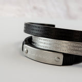 Herrenarmband aus schwarzem Leder mit Edelstahl-Elementen in Silber und Schwarz. Das mehrreihige Design kombiniert eine gravierte Metallplatte mit geprägten Edelstahlbändern und sorgt für einen markanten, modernen Look.