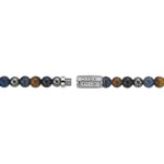 Die Rebel & Rose Halskette - Blue Rain - 6mm besteht aus auffälligen blauen, braunen und silbernen Perlen mit Tigerauge-Akzenten und einem Metallverschluss mit eingraviertem Rebel & Rose Logo.