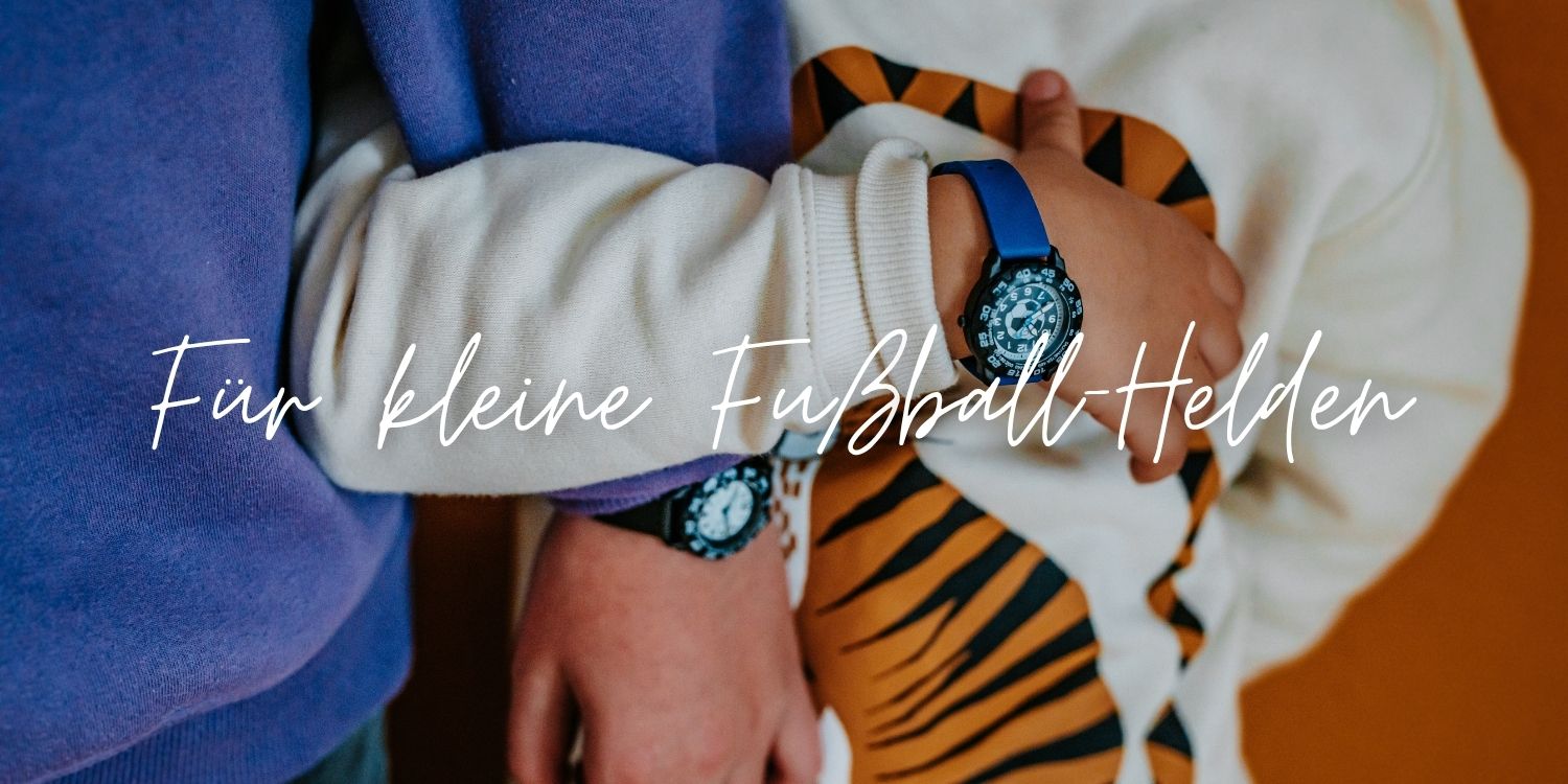Kind trägt eine blaue Fußball-Kinderuhr von Cool Time Kids am Handgelenk. Die sportliche Lernuhr mit Fußball-Design unterstützt kleine Fußballfans spielerisch beim Lernen der Uhrzeit.